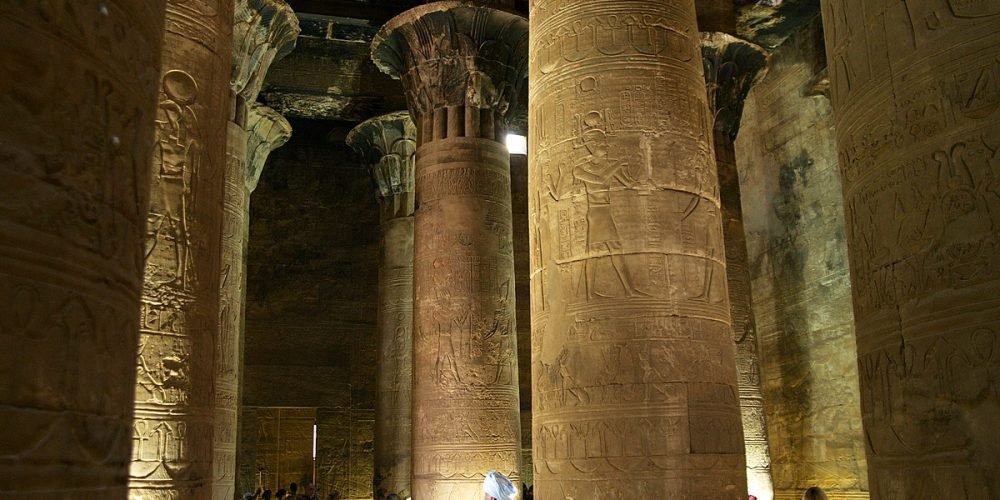 Interior view of Edfu Temple showing stone columns with ancient Egyptian carvings.