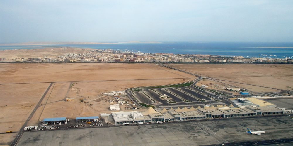 Aerial view of Hurghada International Airport with airplanes on the runway and the Red Sea coastline in the background
