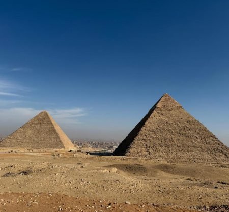 Vue panoramique sur les majestueuses pyramides de Gizeh sous un ciel bleu, un moment fort d'un voyage au Caire et dans une oasis de Siwa