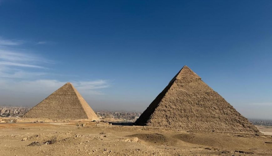 Vue panoramique sur les majestueuses pyramides de Gizeh sous un ciel bleu, un moment fort d'un voyage au Caire et dans une oasis de Siwa