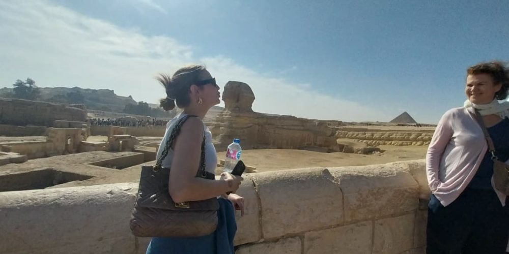 Jeune femme admirant le Grand Sphinx de Gizeh dans le cadre du Forfait au Caire Louxor Assouan et Désert blanc