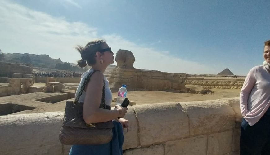 Jeune femme admirant le Grand Sphinx de Gizeh dans le cadre du Forfait au Caire Louxor Assouan et Désert blanc