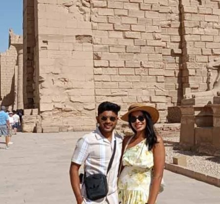 Un couple posant devant l'allée des sphinx à tête de bélier au temple de Karnak, une étape clé d'une journée à Louxor depuis Port de Safaga