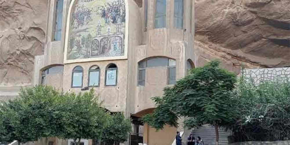 Une touriste posant devant l'entrée sculptée de l'église troglodyte de Saint-Simon au mont Mokattam lors d'une visite spéciale au Caire copte et à Khan el-Khalil