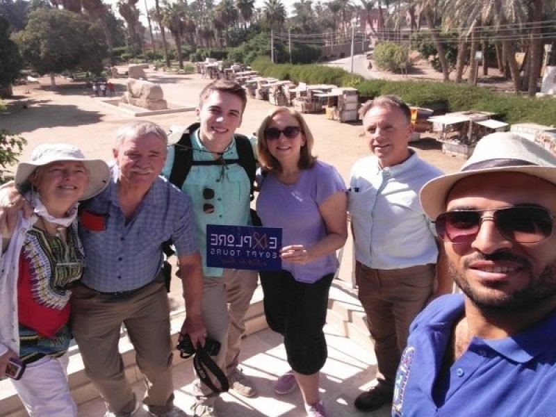 Un groupe de touristes avec leur guide pose joyeusement sur une terrasse surplombant le site de Memphis en Visite les pyramides depuis le port de Sokhna