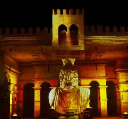 Visitantes assistindo ao show de som e luz na Cidadela de Qaitbay à beira do Mediterrâneo.