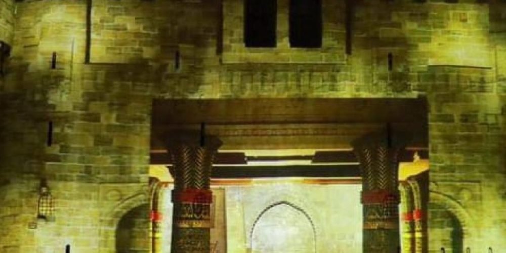 Projeções de luz destacando as muralhas da Cidadela de Qaitbay durante o espetáculo noturno.