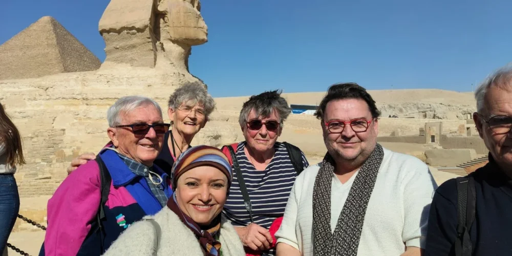 Un grupo de turistas posa frente a la Gran Esfinge de Guiza.