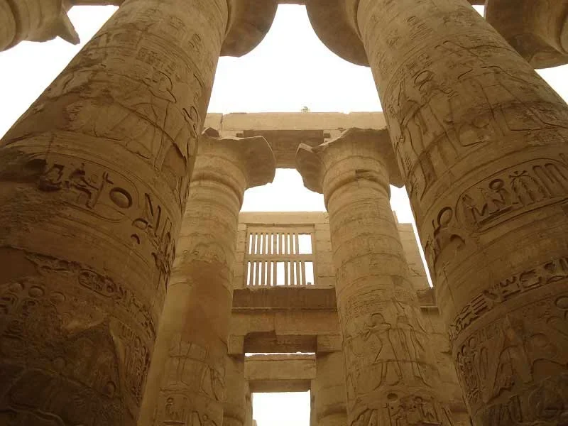 Grandes columnas del Templo de Karnak en Egipto, decoradas con jeroglíficos y relieves.