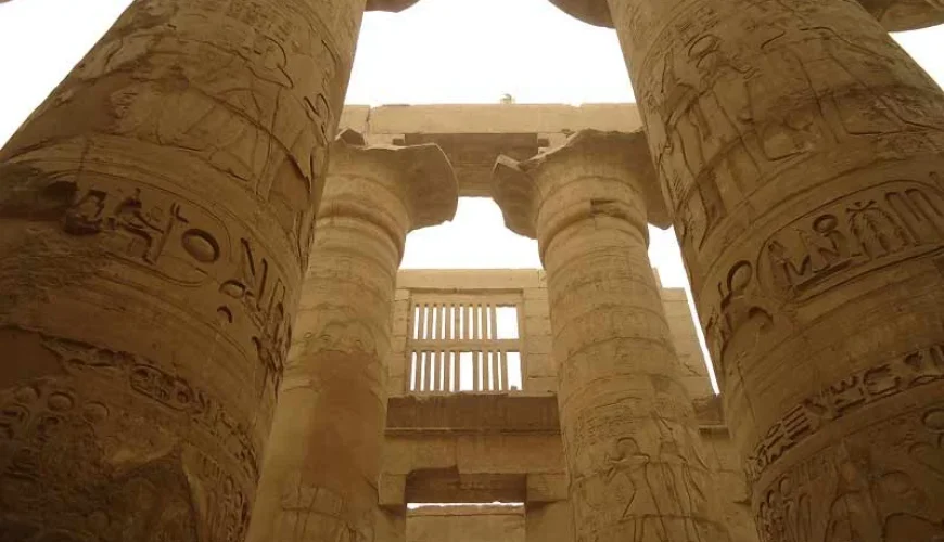 Grandes columnas del Templo de Karnak en Egipto, decoradas con jeroglíficos y relieves.