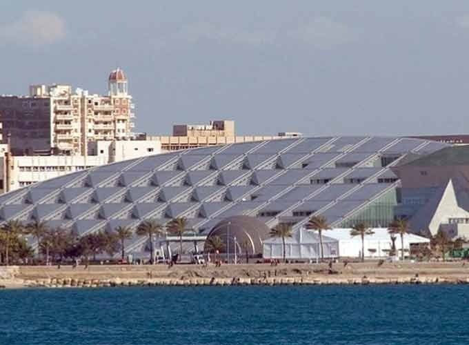Fachada moderna da Biblioteca Alexandrina, com sua arquitetura circular à beira do Mediterrâneo.