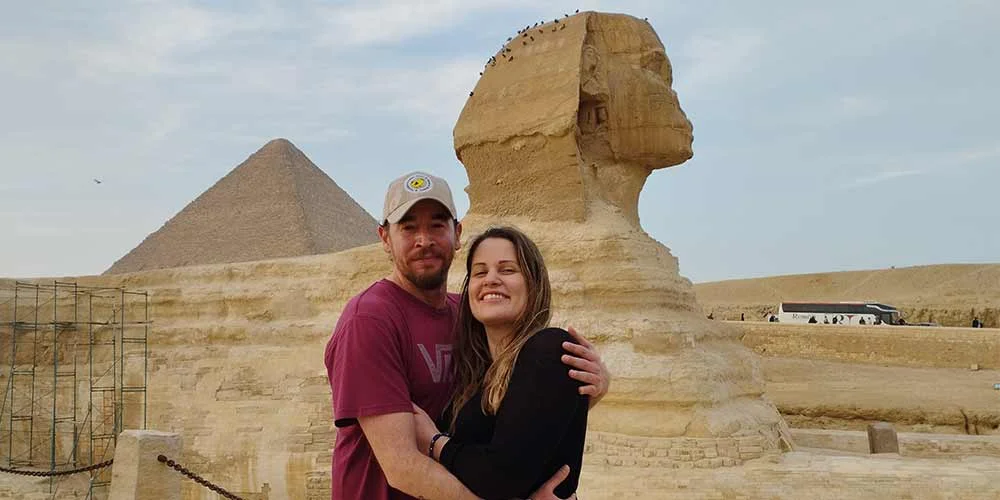 Una pareja tomando una foto junto a la Gran Esfinge de Giza