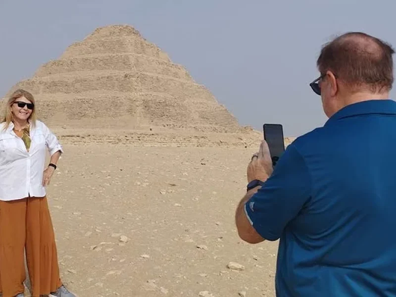 Un marido fotografía a su esposa frente a la Pirámide Escalonada de Saqqara.