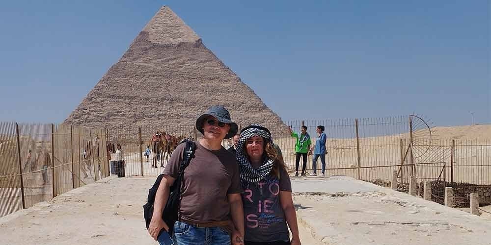 A couple visiting the Pyramids of Giza, enjoying the view of the ancient wonders