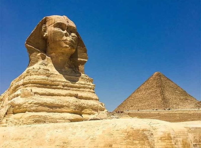 The Great Sphinx standing beside one of the Pyramids of Giza