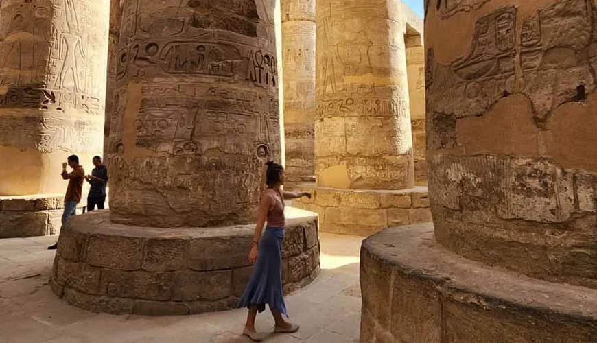 Una joven caminando entre las majestuosas columnas del Templo de Karnak