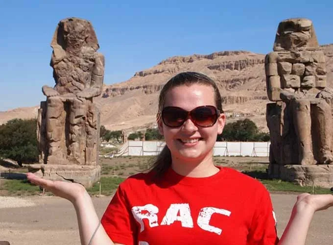 Una chica posando frente a los Colosos de Memnón