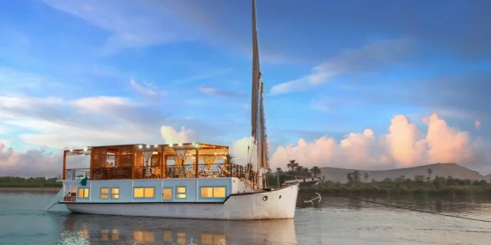 Dahabiya elegante navegando por el río Nilo.