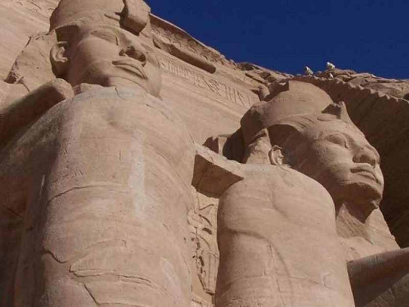 Fachada do Templo de Abu Simbel com estátuas monumentais de Ramsés II esculpidas na rocha.