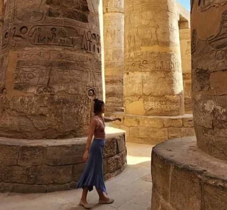 Um turista tira uma fotografia no interior do Templo de Karnak, entre as colunas do templo.