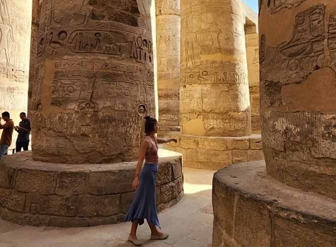Um turista tira uma fotografia no interior do Templo de Karnak, entre as colunas do templo.