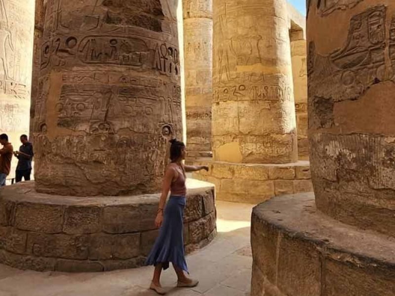 Um turista tira uma fotografia no interior do Templo de Karnak, entre as colunas do templo.