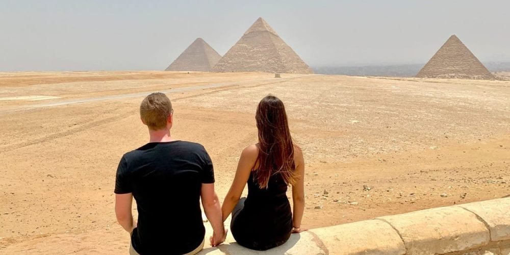 Turistas visitando as Pirâmides de Gizé, uma das Sete Maravilhas do Mundo Antigo.