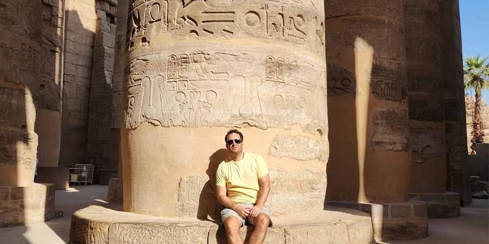 Complexo do Templo de Karnak com a Grande Sala Hipostila, destacando colunas gigantes cobertas por hieróglifos, em Luxor, Egito.