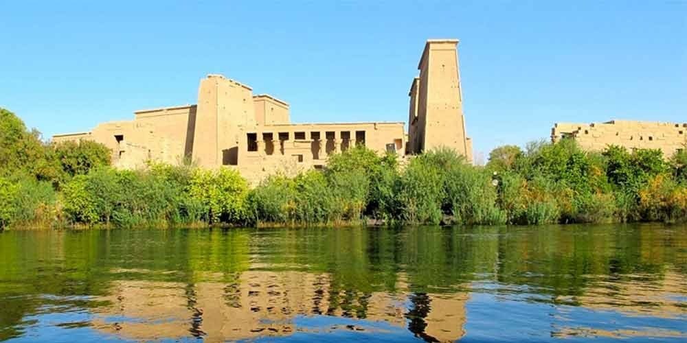 Templo de Philae em Aswan, com colunas elegantes e o rio ao redor.
