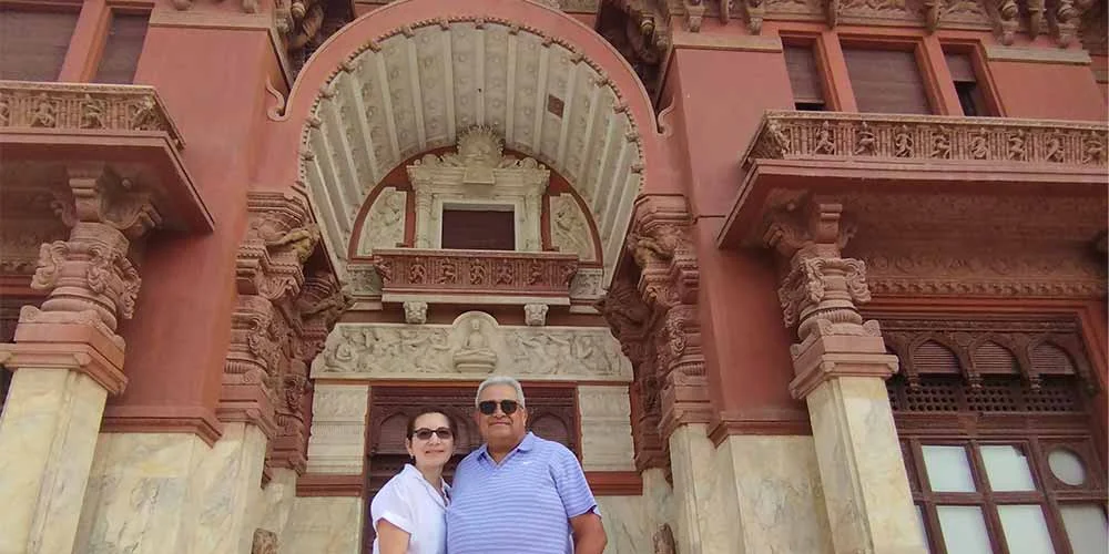 A couple taking a photo in front of Baron Palace in Cairo