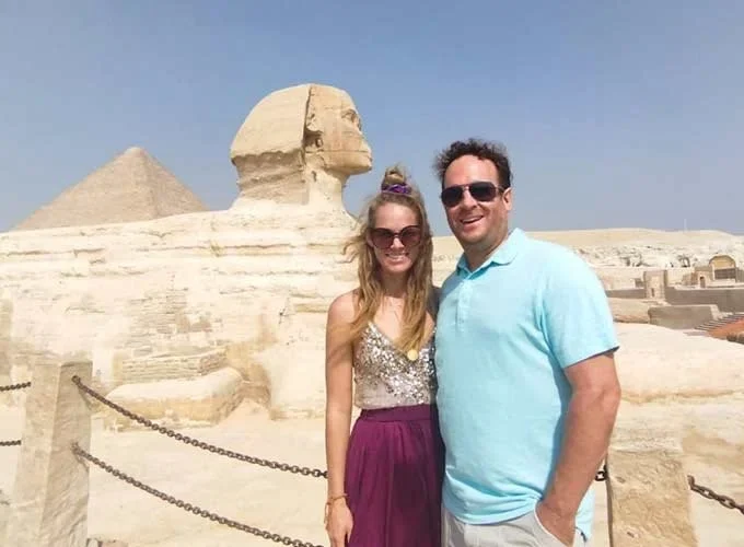 A couple taking a photo with the Great Sphinx of Giza