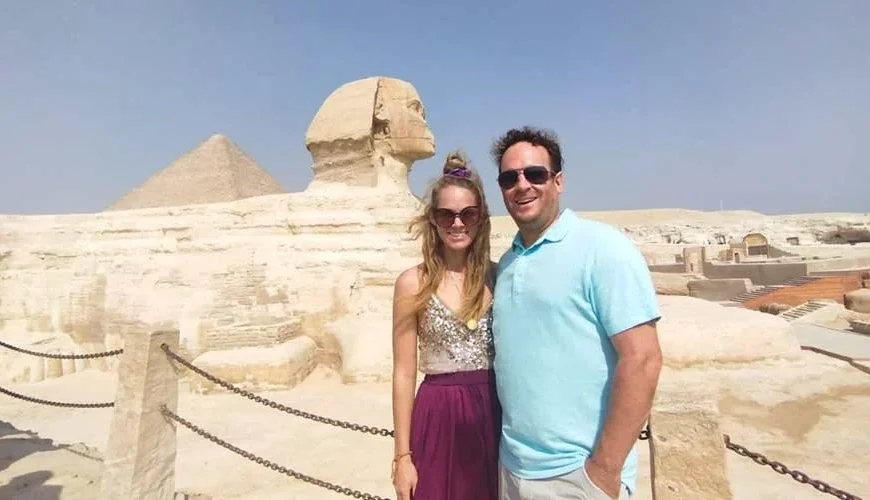 A couple taking a photo with the Great Sphinx of Giza