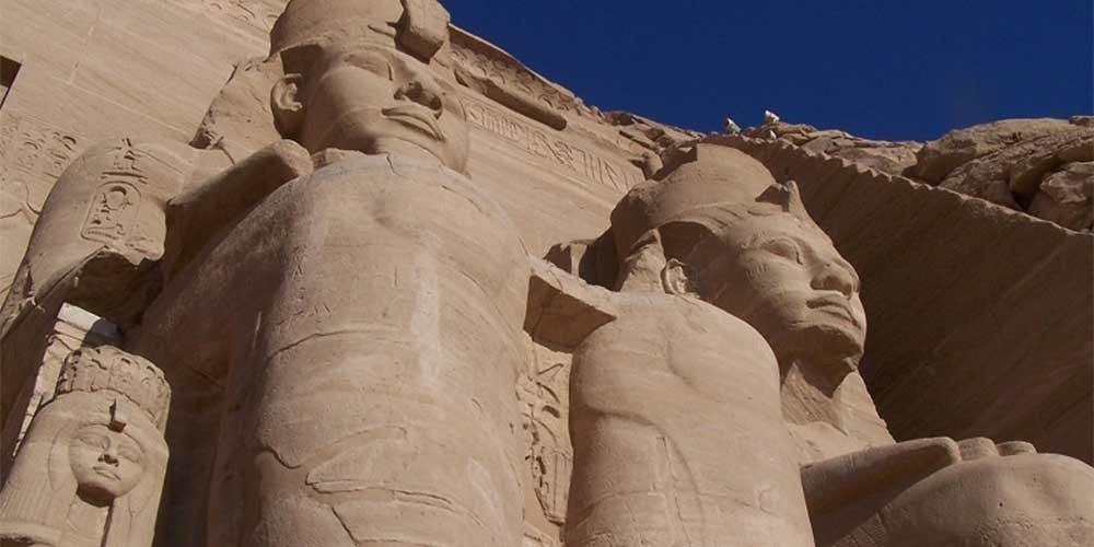 Vista panorâmica dos templos de Abu Simbel, esculpidos nas rochas à beira do deserto.