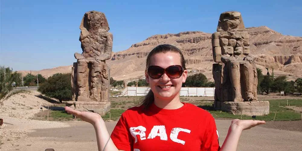 Turista tomando una foto frente a los Colosos de Memnón