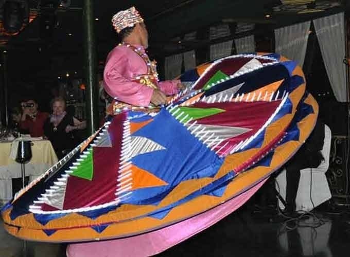 Performers spinning colorful Tanura show during a dinner cruise