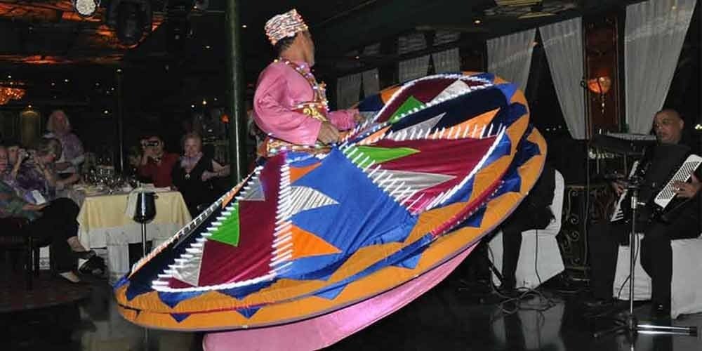Performers spinning colorful Tanura show during a dinner cruise