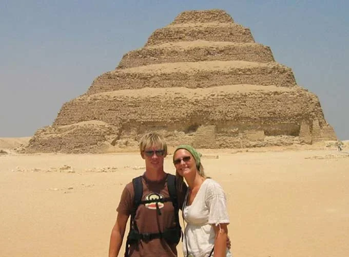 A couple taking a photo in front of the Step Pyramid of Saqqara