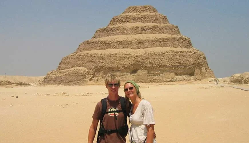 A couple taking a photo in front of the Step Pyramid of Saqqara