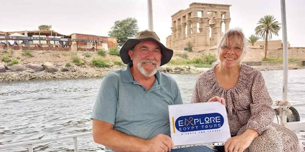 Vista do Templo de Philae, em Assuã, com seus pórticos e colunas refletidos nas águas do rio Nilo.