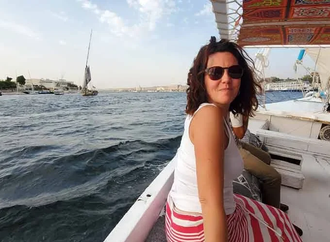 A tourist enjoying a felucca ride on the Nile River surrounded by fresh air and water