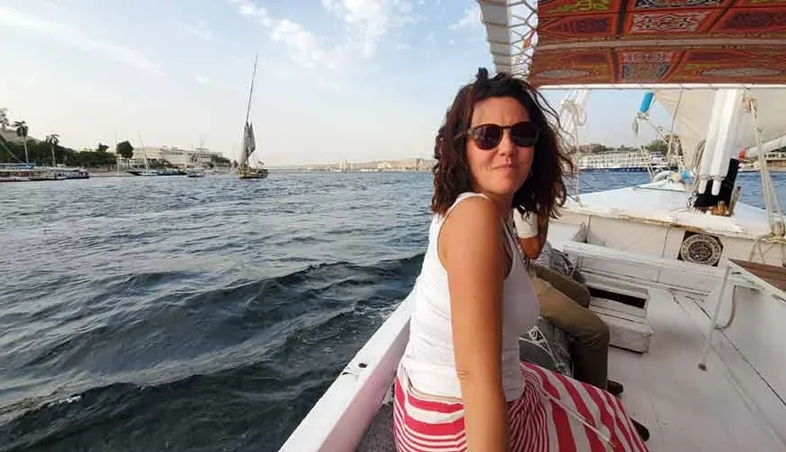 A tourist enjoying a felucca ride on the Nile River surrounded by fresh air and water