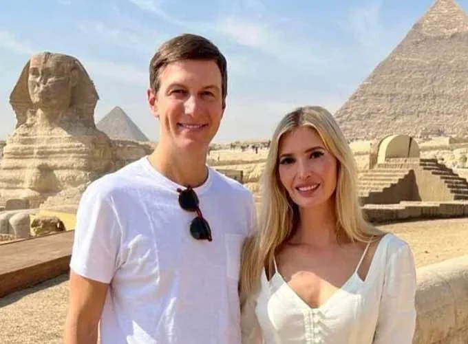 A couple posing happily in front of the Great Pyramids of Giza.