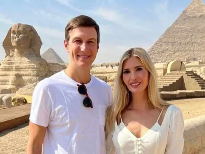 A couple posing happily in front of the Great Pyramids of Giza.