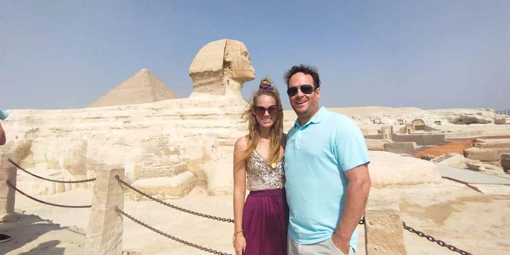 A couple enjoying their time and taking a photo with the Sphinx.