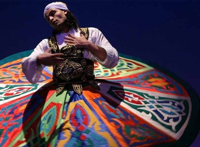 Cruzeiro navegando pelo rio Nilo com paisagens verdes, vilarejos e templos históricos ao fundo.