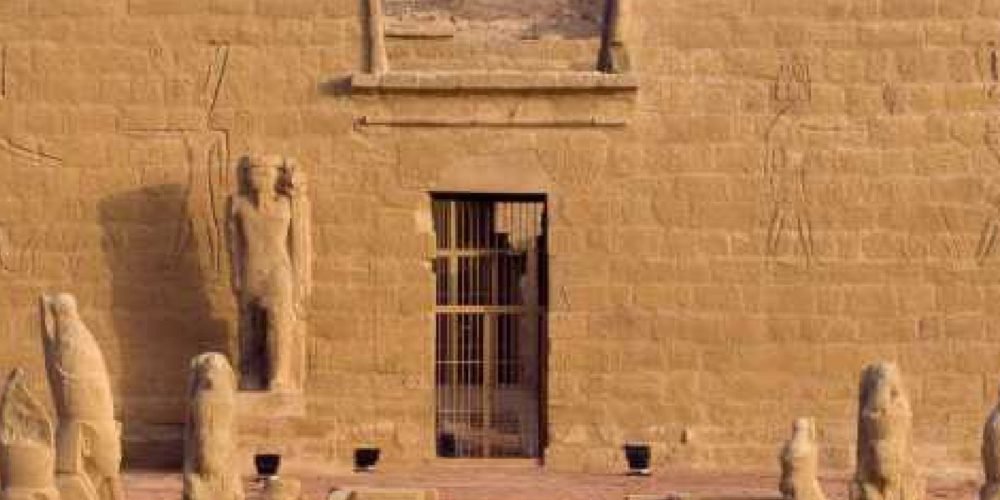 Visitantes explorando o Templo de Wadi El‑Sebua, templo do período do faraó Ramsés II decorado com relevos antigos.