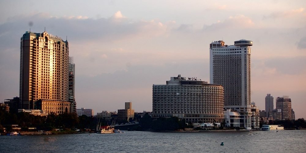 Feluca tradicional navegando pelo rio Nilo entre Aswan e Kom Ombo, com paisagens naturais ao redor.