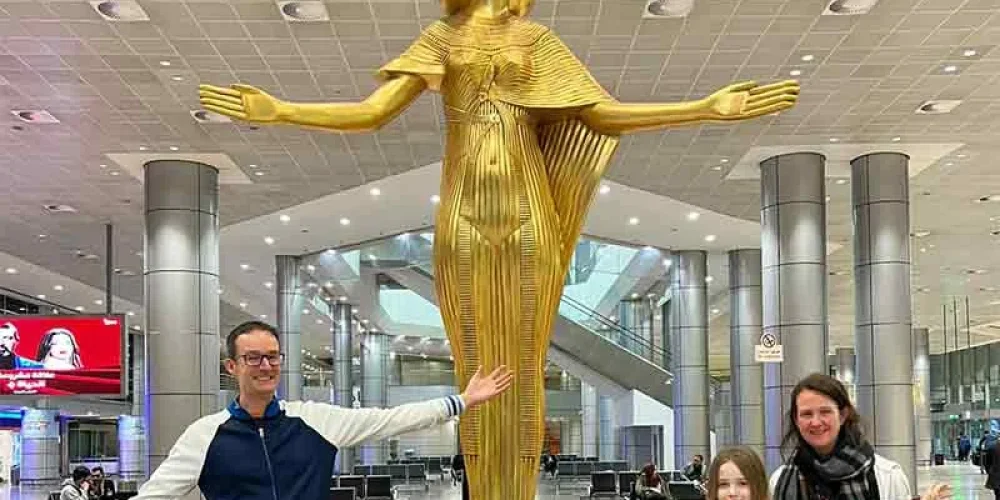 A family taking a photo with a statue inside Cairo International Airport