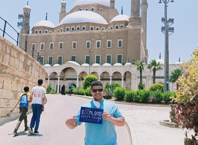 A tourist holding the company's sign in front of the Citadel of Saladin