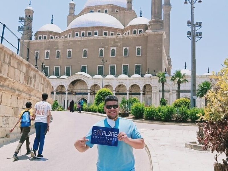A tourist holding the company's sign in front of the Citadel of Saladin